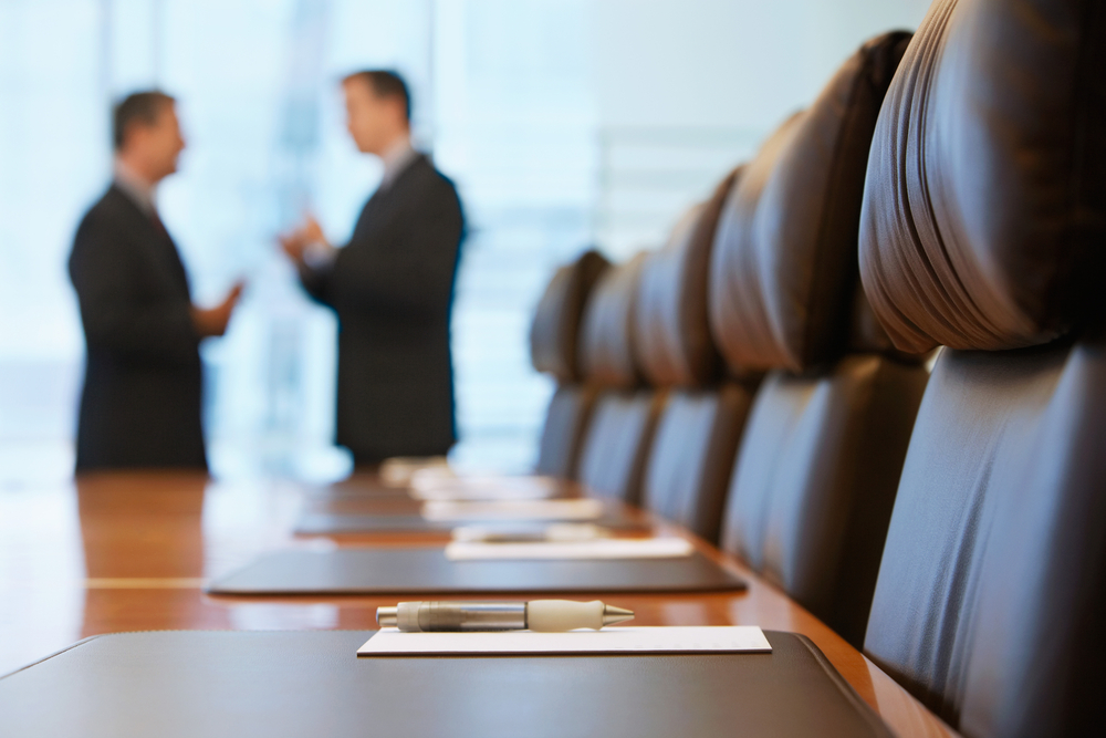 Side,View,Of,Two,Blurred,Businessmen,Talking,In,Conference,Room