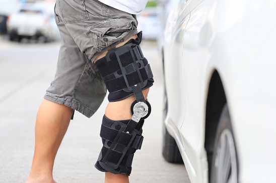 Senior,Man,Wear,Knee,Support,Brace,On,Leg,Standing,At
