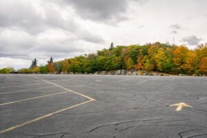 Empty,Parking,Lot,Bordered,With,Autumnal,Trees,On,The,Top